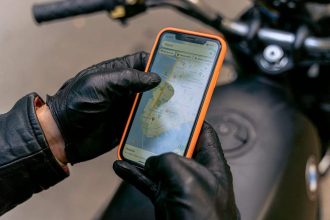 Motard utilisant une application de navigation sur une route sinueuse