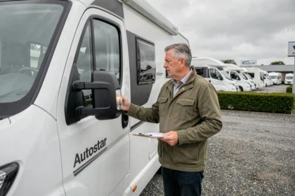 Homme inspectant un camping-car Autostar occasion chez un concessionnaire professionnel