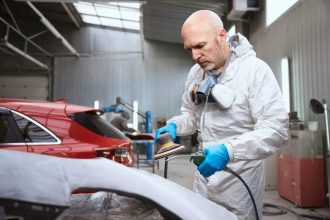 Mécanicien utilisant un outil pneumatique pour réparer une voiture