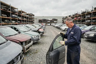 Casse automobile Lille Marin avec mécanicien inspectant des pièces détachées dans un parc de véhicules hors d'usage