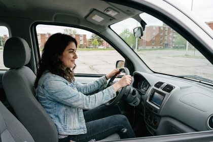 Jeune femme au volant d'une microcar urbaine Simplici S1