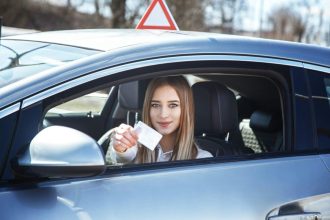 Fille joyeuse conduisant une voiture d'apprentissage