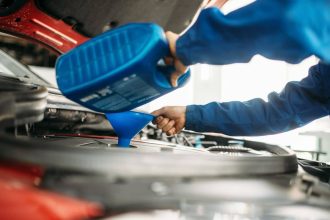 Technicien effectuant une vidange d'huile dans un moteur de voiture