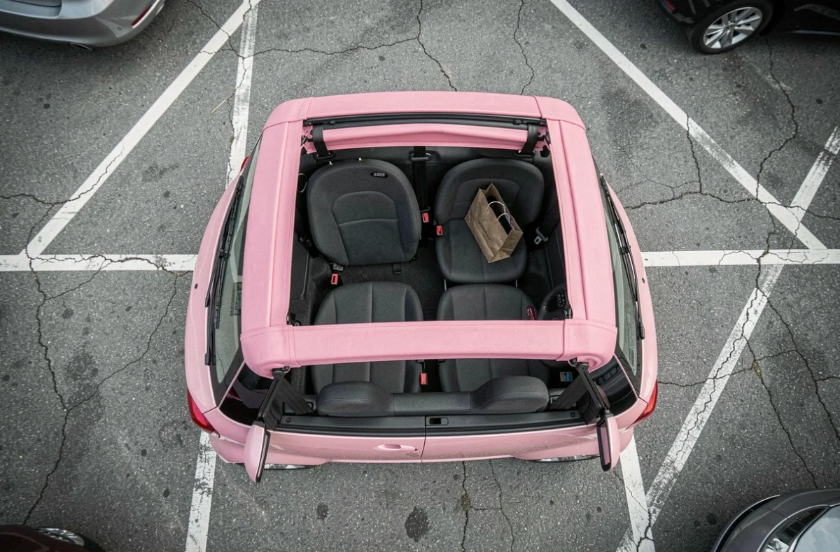 Vue de dessus d'une voiture sans permis décapotable rose dans un parking du quotidien